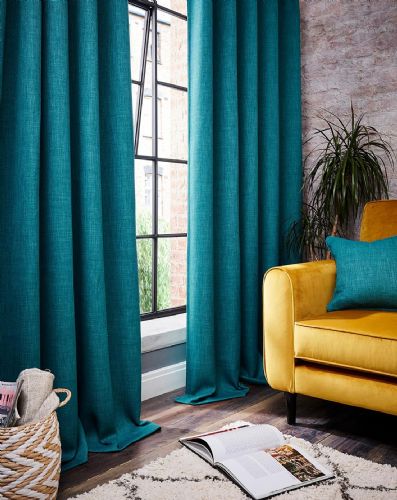 teal curtains in a room with a bright yellow sofa and teal cushion