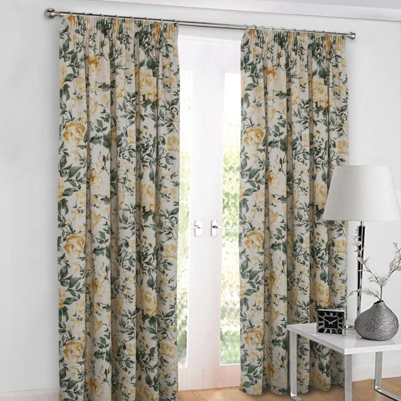 Curtains with a pattern of yellow roses and greeery hanging from a silver curtain pole against a window on a white wall
